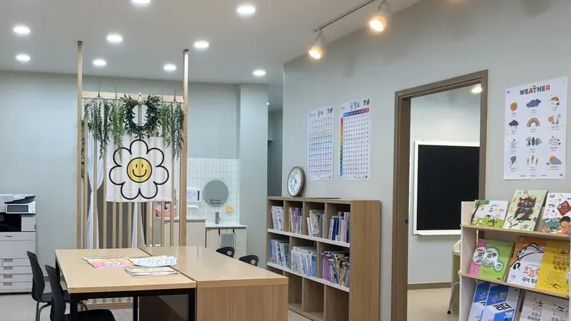 트이다학원 남악점 메인 홀 책장 위의 바늘 시계와 벽의 숫자표 포스터