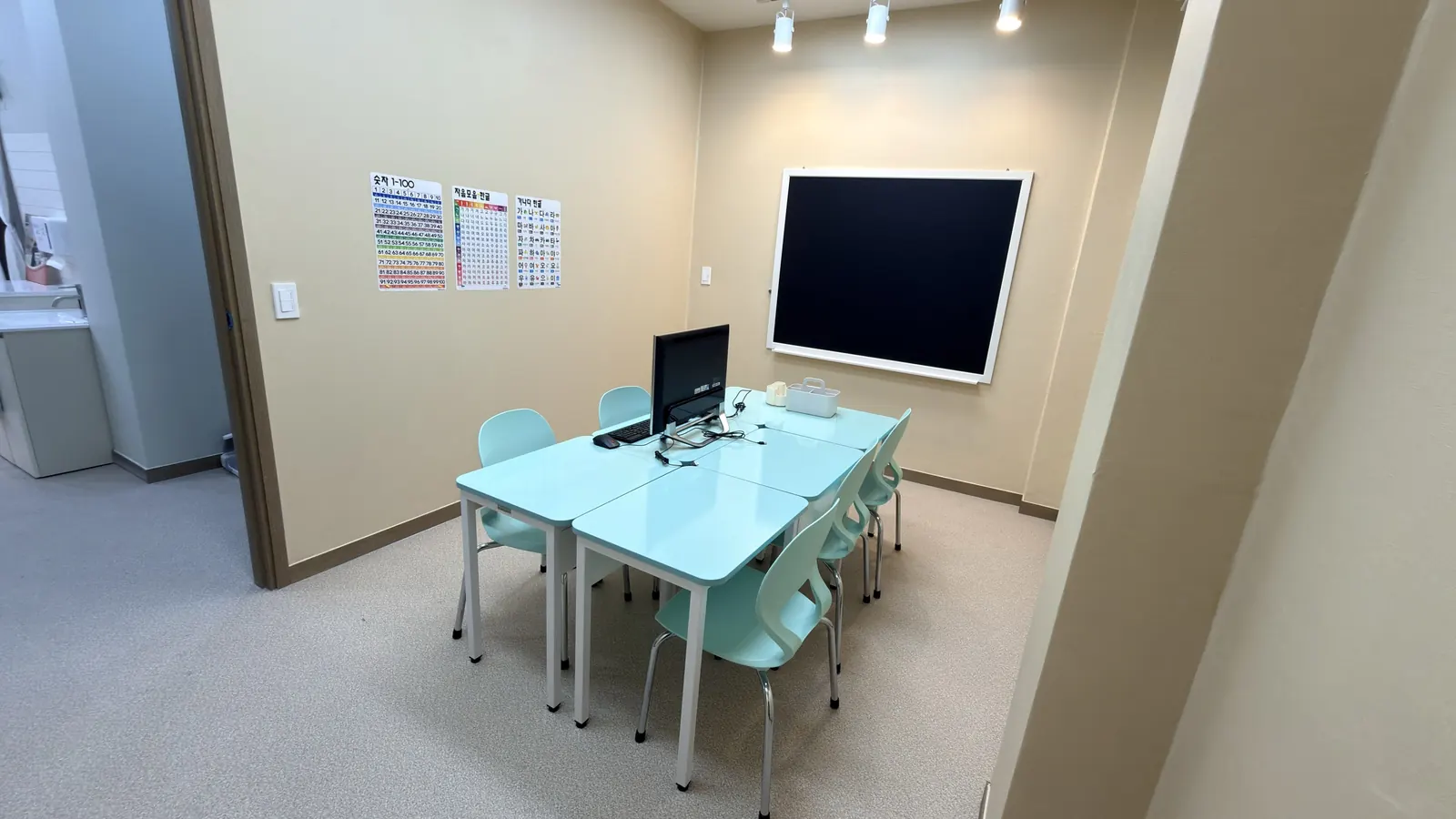 하늘색 테이블과 민트 의자가 놓인 아담한 교실