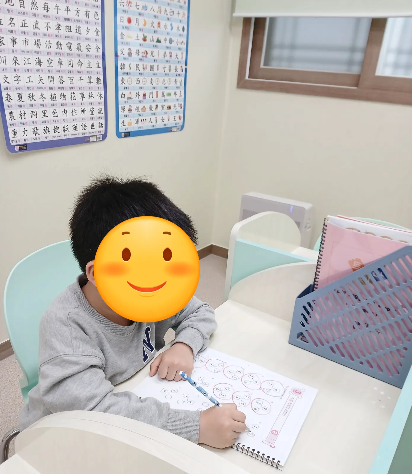 민트 칸막이 책상에서 연산 교재를 푸는 아이